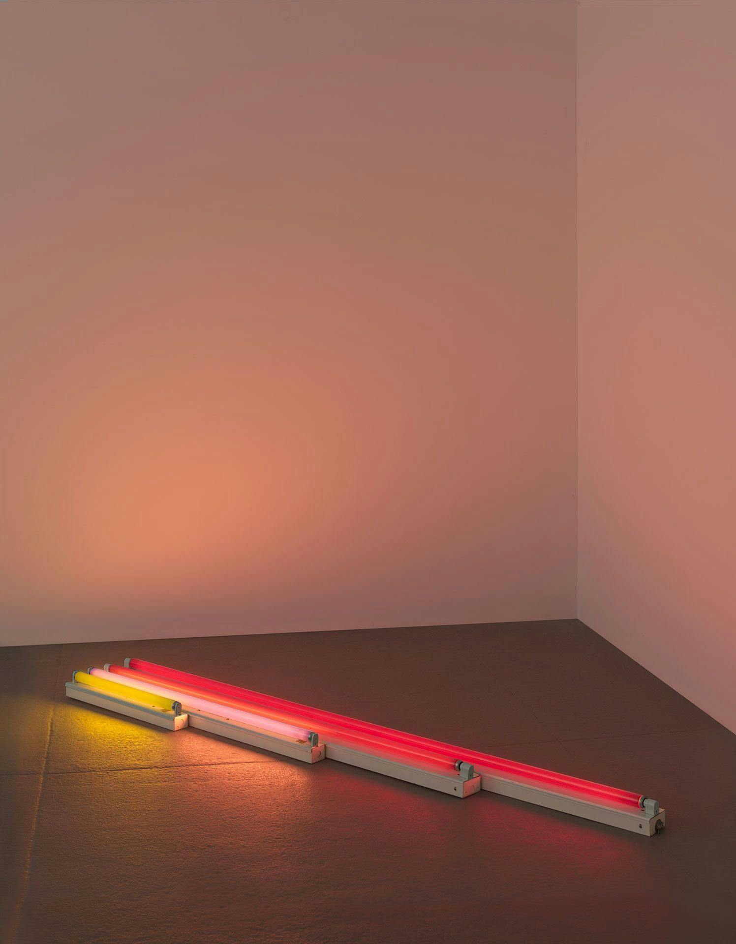 A sculpture in yellow, pink, and red fluorescent light by Dan Flavin, titled gold, pink and red, red, dated 1964.